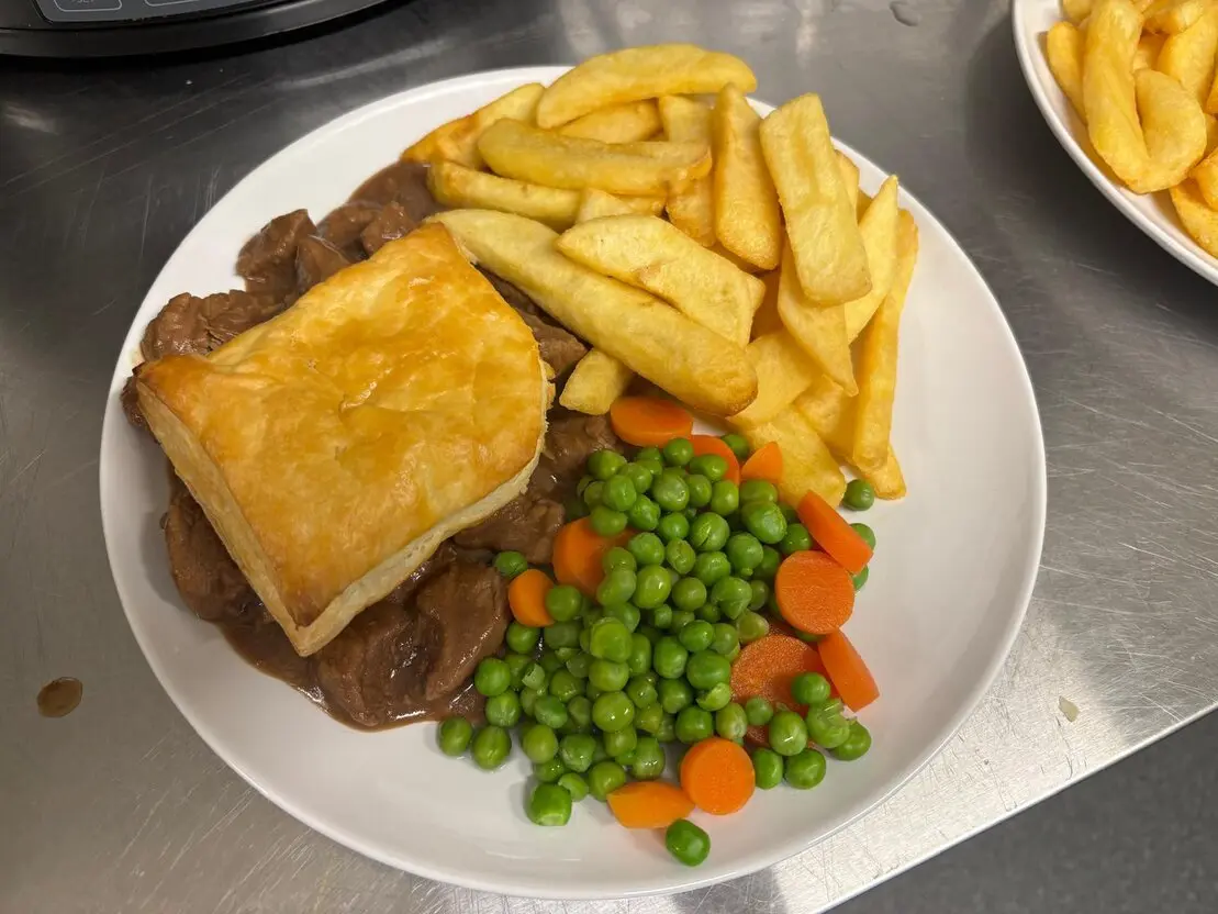 Golden steak pie served with chips and gravy